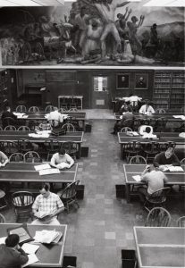 A black and white overhead photo of law students studying beneath the Curry mural.